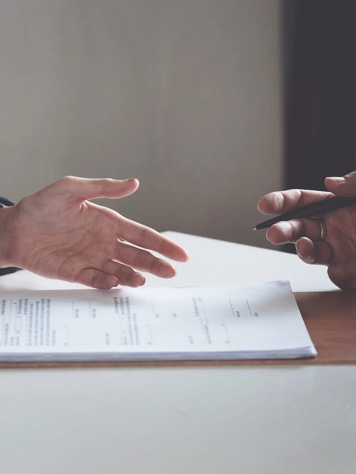 Two people shaking hands over case documents